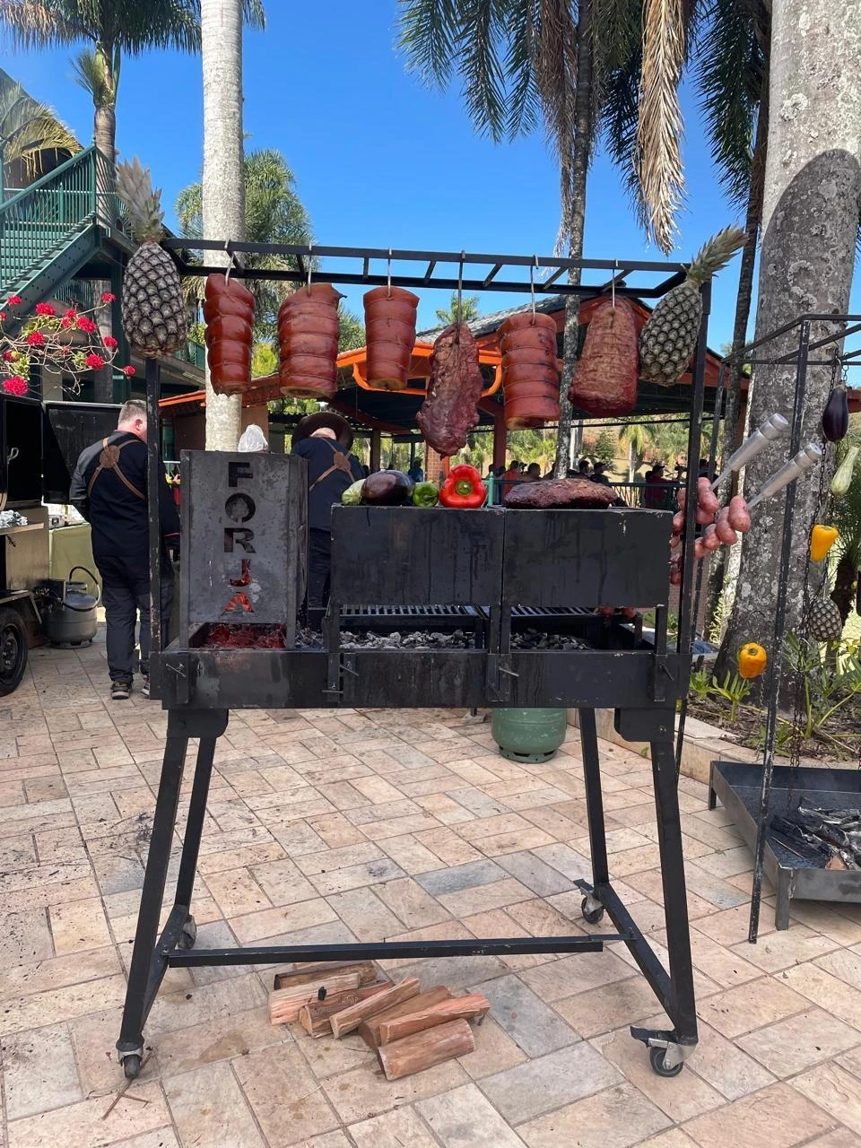 Carnes e abacaxis pendurados na estação de fogo