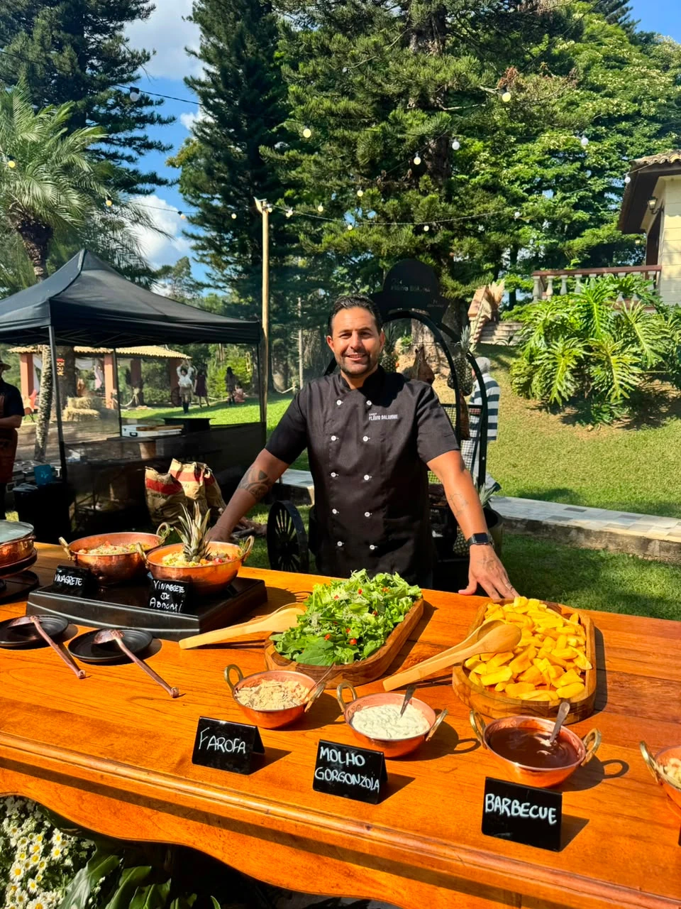 Chef Flávio junto à mesa de buffet e acompanhamentos